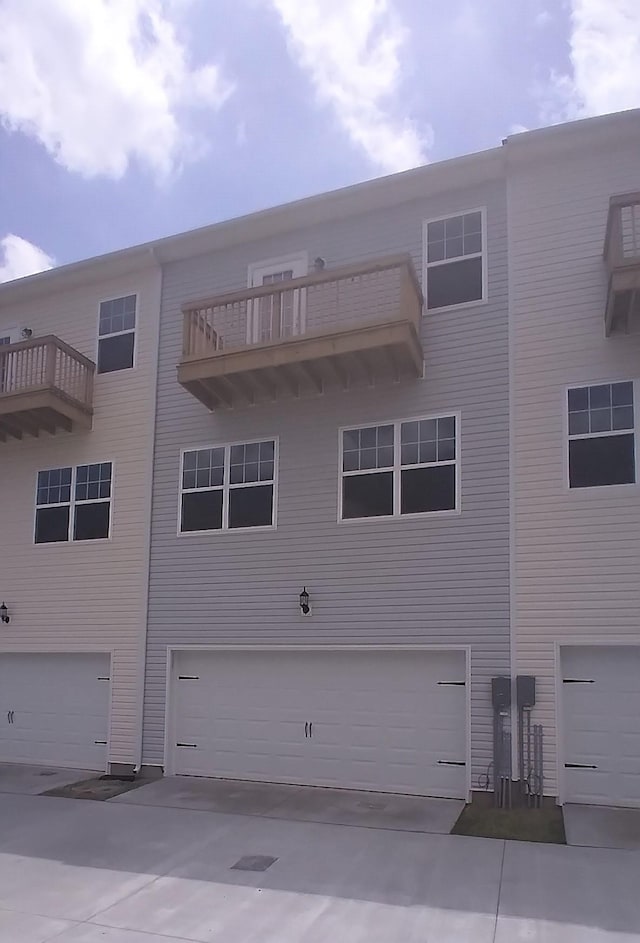 rear view of property with a garage and a balcony