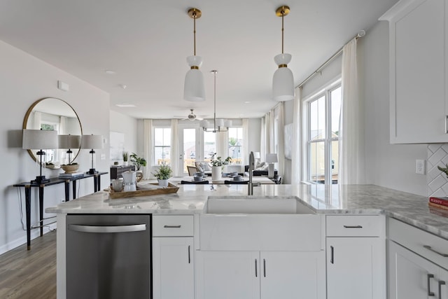 kitchen with stainless steel dishwasher, light stone countertops, and white cabinets