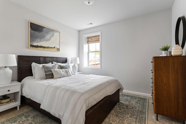 bedroom with dark colored carpet, visible vents, and baseboards