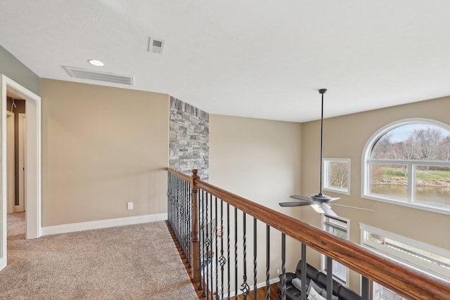 hall with carpet floors, recessed lighting, visible vents, and baseboards