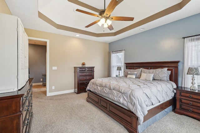 bedroom with recessed lighting, a raised ceiling, a ceiling fan, light carpet, and baseboards