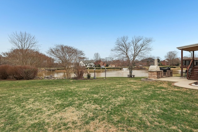 view of yard featuring stairway and a water view