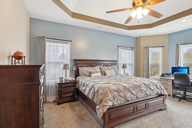 bedroom with recessed lighting, a tray ceiling, a ceiling fan, and light colored carpet