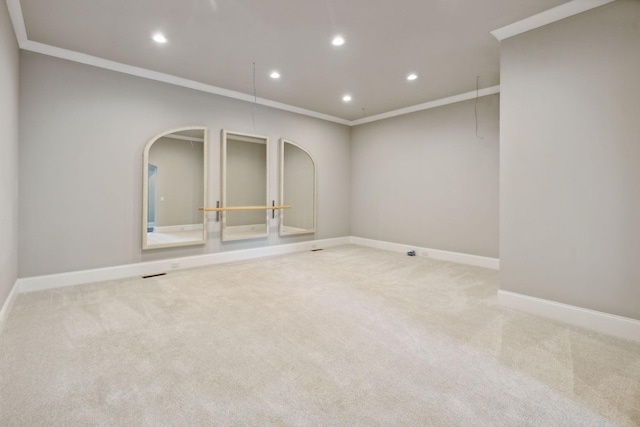 spare room with crown molding, recessed lighting, baseboards, and light colored carpet