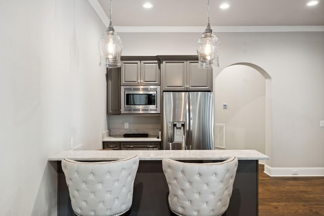 kitchen featuring arched walkways, crown molding, stainless steel appliances, recessed lighting, and dark wood-type flooring