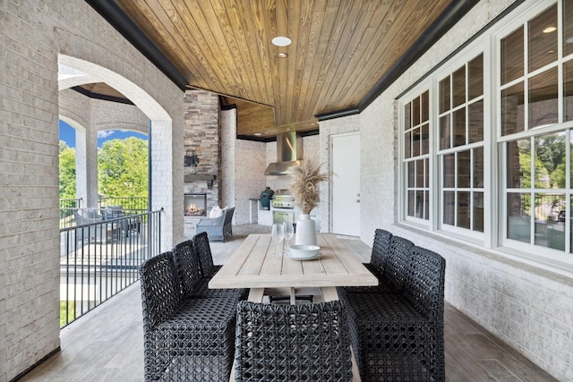 view of patio / terrace featuring grilling area, an outdoor stone fireplace, and outdoor dining area