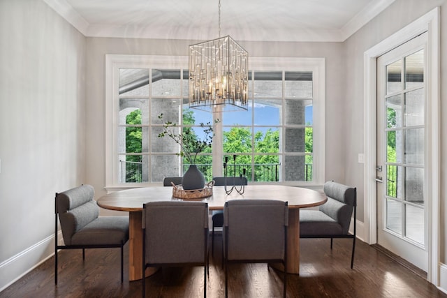 dining area with crown molding, dark wood finished floors, baseboards, and an inviting chandelier