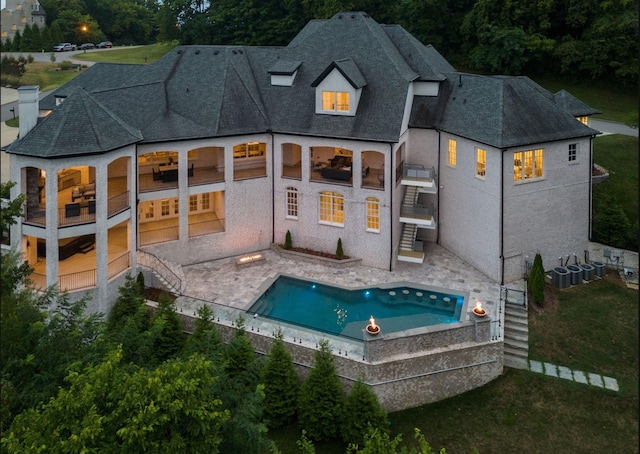 back of house featuring stairs, a patio, and a fenced in pool