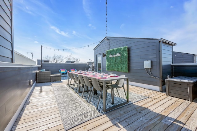 wooden terrace featuring outdoor dining space, fence, and an outdoor living space