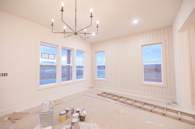 unfurnished room featuring baseboards and a chandelier