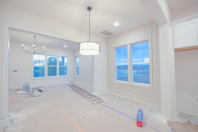 unfurnished dining area featuring an inviting chandelier, visible vents, and baseboards