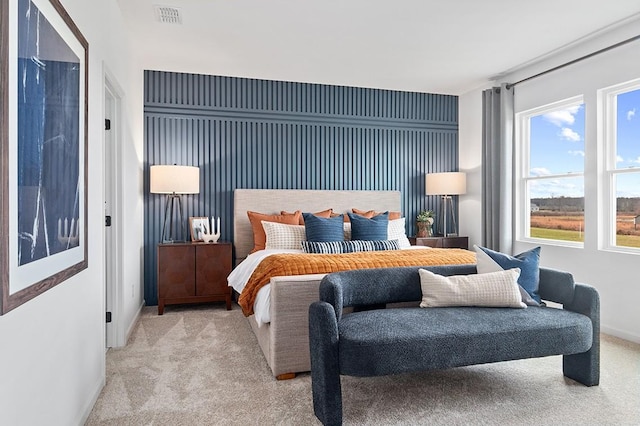 bedroom featuring baseboards, visible vents, and light colored carpet