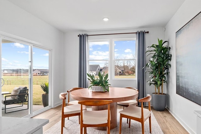 dining room featuring light wood-style floors, baseboards, and recessed lighting