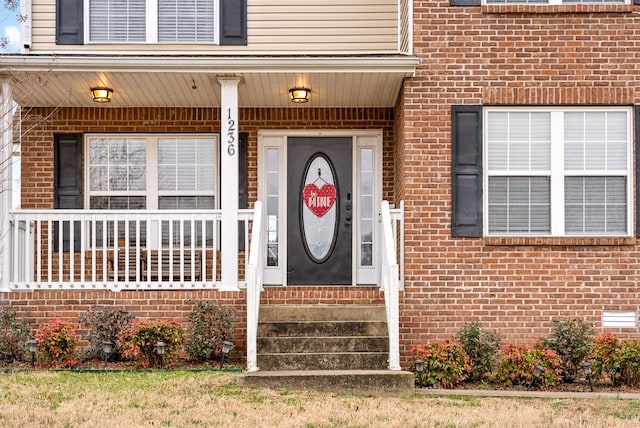 property entrance featuring crawl space and brick siding