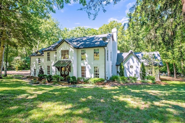 view of front of property featuring a chimney, a front yard, fence, and stucco siding