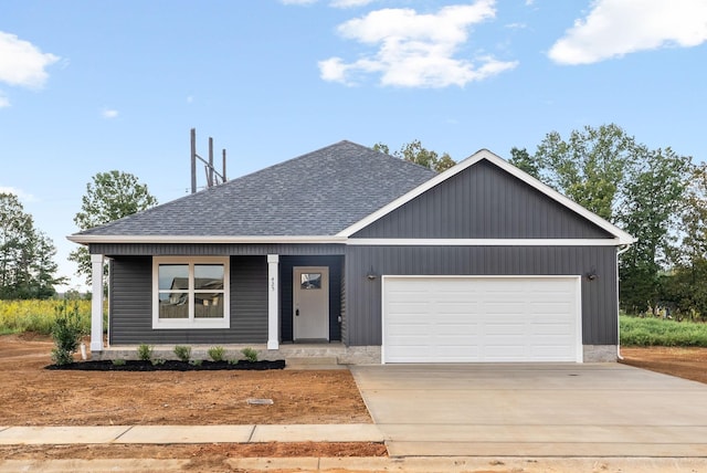 view of front of property with a garage, concrete driveway, and roof with shingles