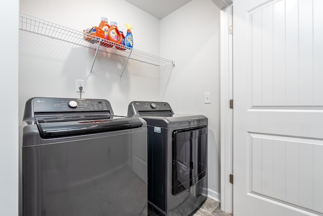 clothes washing area featuring washing machine and dryer and baseboards