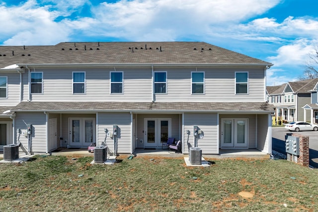 rear view of property featuring central air condition unit, a yard, a patio, and french doors