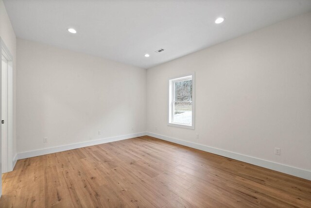 empty room with light wood finished floors, baseboards, visible vents, and recessed lighting