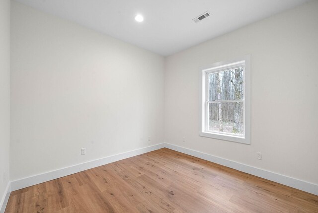 empty room with light wood-style flooring, visible vents, baseboards, and recessed lighting