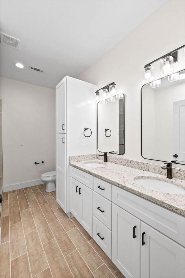 bathroom with visible vents, a sink, and toilet