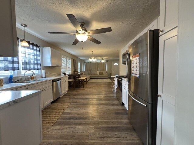 kitchen with stainless steel appliances, light countertops, white cabinets, and dark wood finished floors