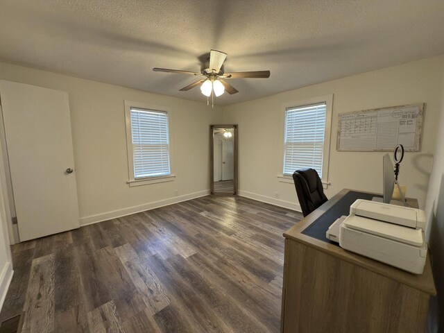 unfurnished office with ceiling fan, a textured ceiling, dark wood finished floors, and baseboards