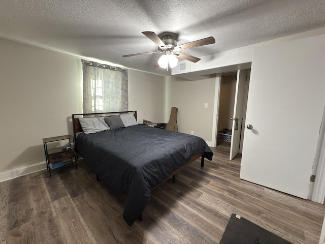 bedroom with dark wood-style floors, visible vents, ceiling fan, a textured ceiling, and baseboards