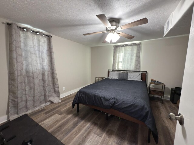 bedroom featuring a textured ceiling, dark wood finished floors, and visible vents