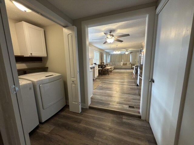 laundry room with ceiling fan, a textured ceiling, washer and dryer, cabinet space, and dark wood finished floors