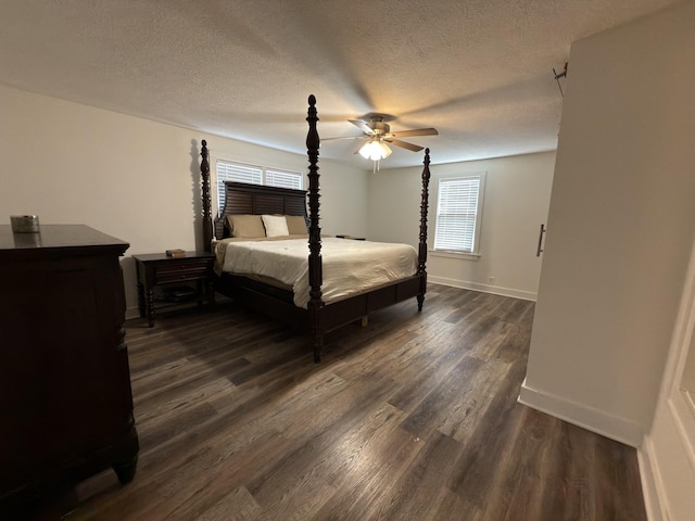 bedroom with a ceiling fan, a textured ceiling, baseboards, and dark wood-style flooring