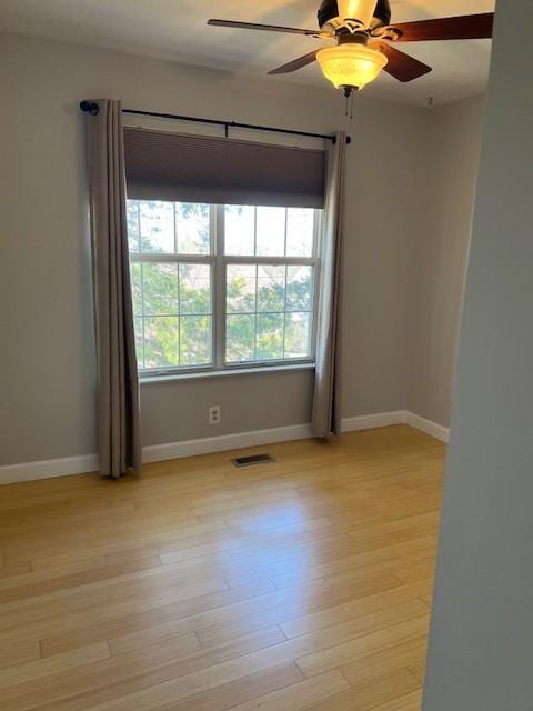 unfurnished room with light wood-style floors, visible vents, and plenty of natural light