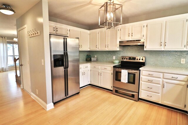 kitchen with stainless steel appliances, hanging light fixtures, light countertops, and under cabinet range hood