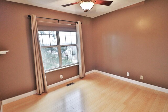 unfurnished room featuring light wood-type flooring, visible vents, and baseboards