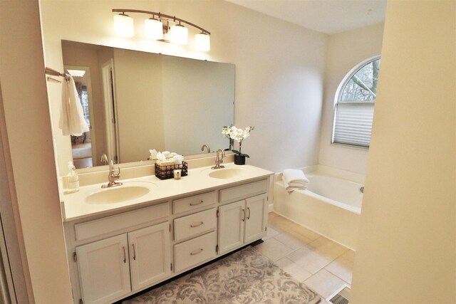 bathroom featuring double vanity, tile patterned flooring, a sink, and a bath