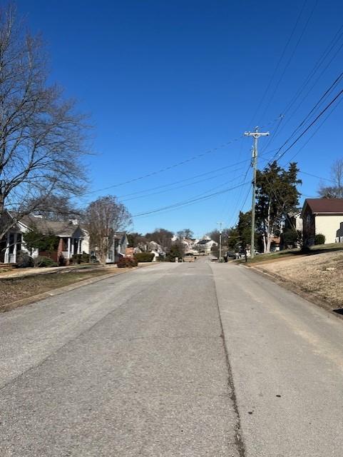 view of street featuring a residential view and curbs