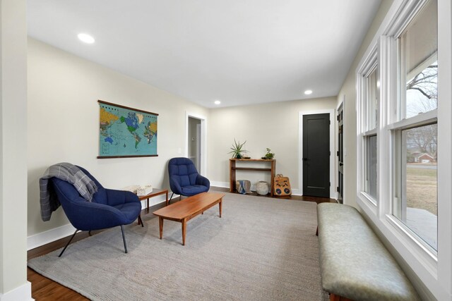 living area featuring baseboards, wood finished floors, and recessed lighting