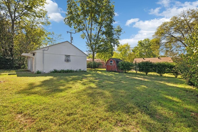 view of yard with a shed, an outdoor structure, and fence