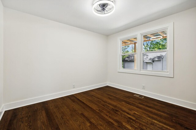 unfurnished room with visible vents, baseboards, and wood finished floors