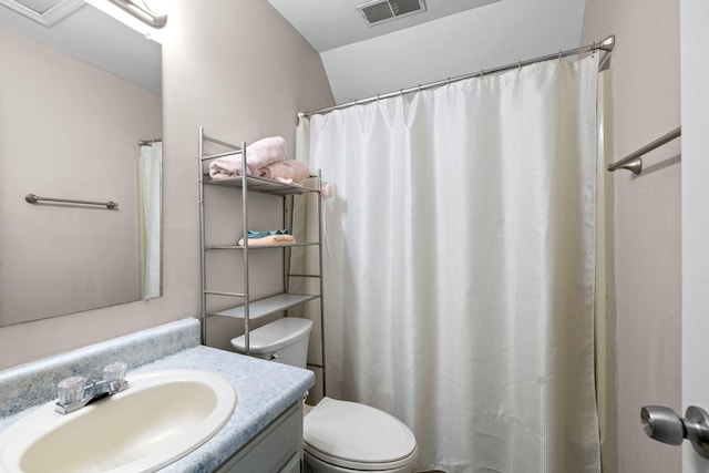 bathroom with toilet, vanity, and visible vents