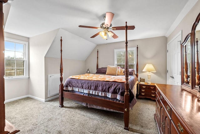 bedroom with multiple windows, baseboards, vaulted ceiling, and light colored carpet