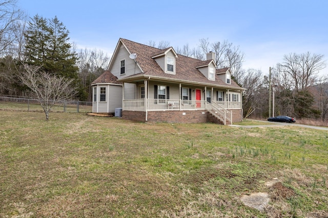 new england style home with a chimney, a porch, roof with shingles, fence, and a front lawn