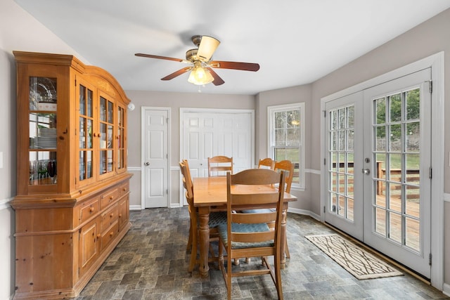 dining room with french doors, stone finish floor, baseboards, and ceiling fan