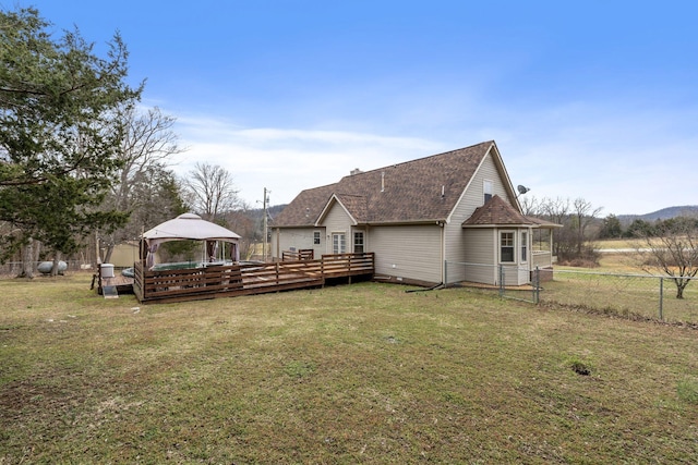 back of house featuring a gazebo, a lawn, a wooden deck, and fence