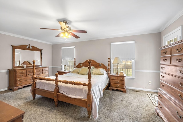 carpeted bedroom with baseboards, visible vents, ceiling fan, and crown molding