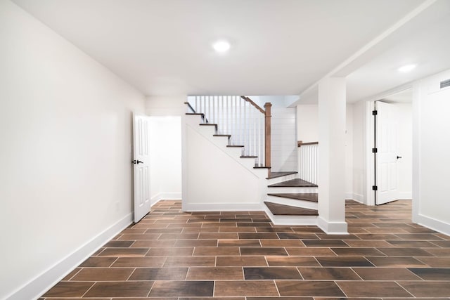 stairway featuring wood tiled floor, baseboards, and recessed lighting