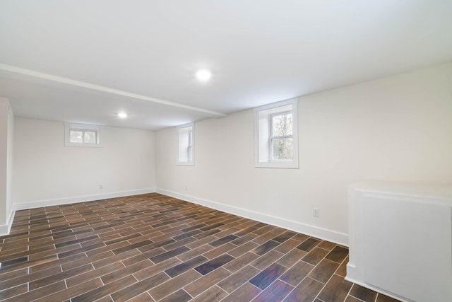 basement with recessed lighting, dark wood finished floors, and baseboards