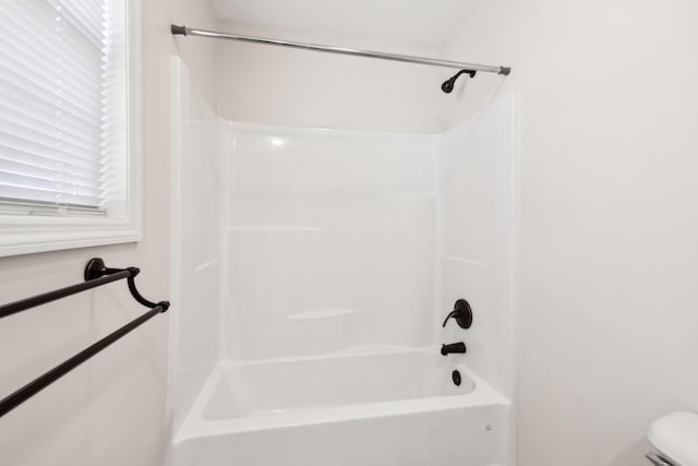 bathroom with bathtub / shower combination and toilet