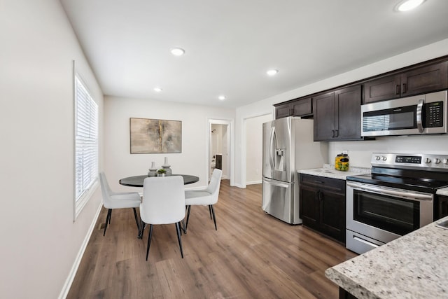 kitchen with dark brown cabinetry, light stone counters, dark wood-type flooring, stainless steel appliances, and recessed lighting