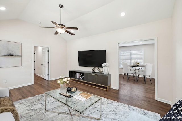 living area with dark wood-type flooring, lofted ceiling, ceiling fan, and baseboards